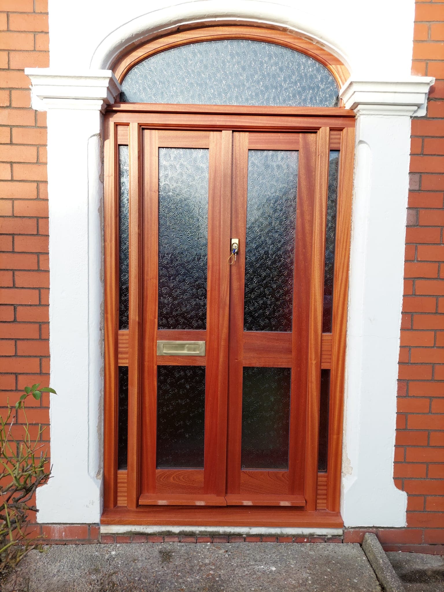 Traditional hardwood front door with rich brown finish and glass panels