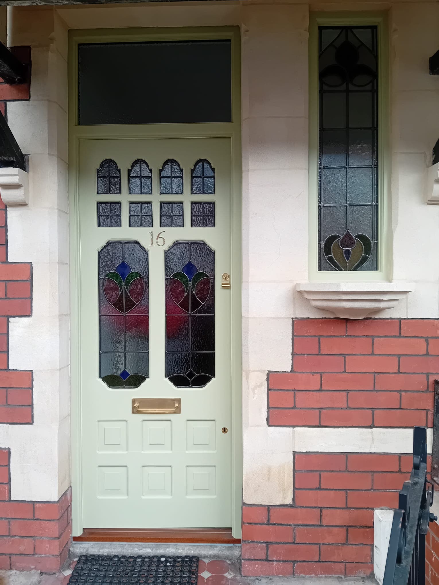 Sage green Victorian door with decorative stained glass and coordinated side window
