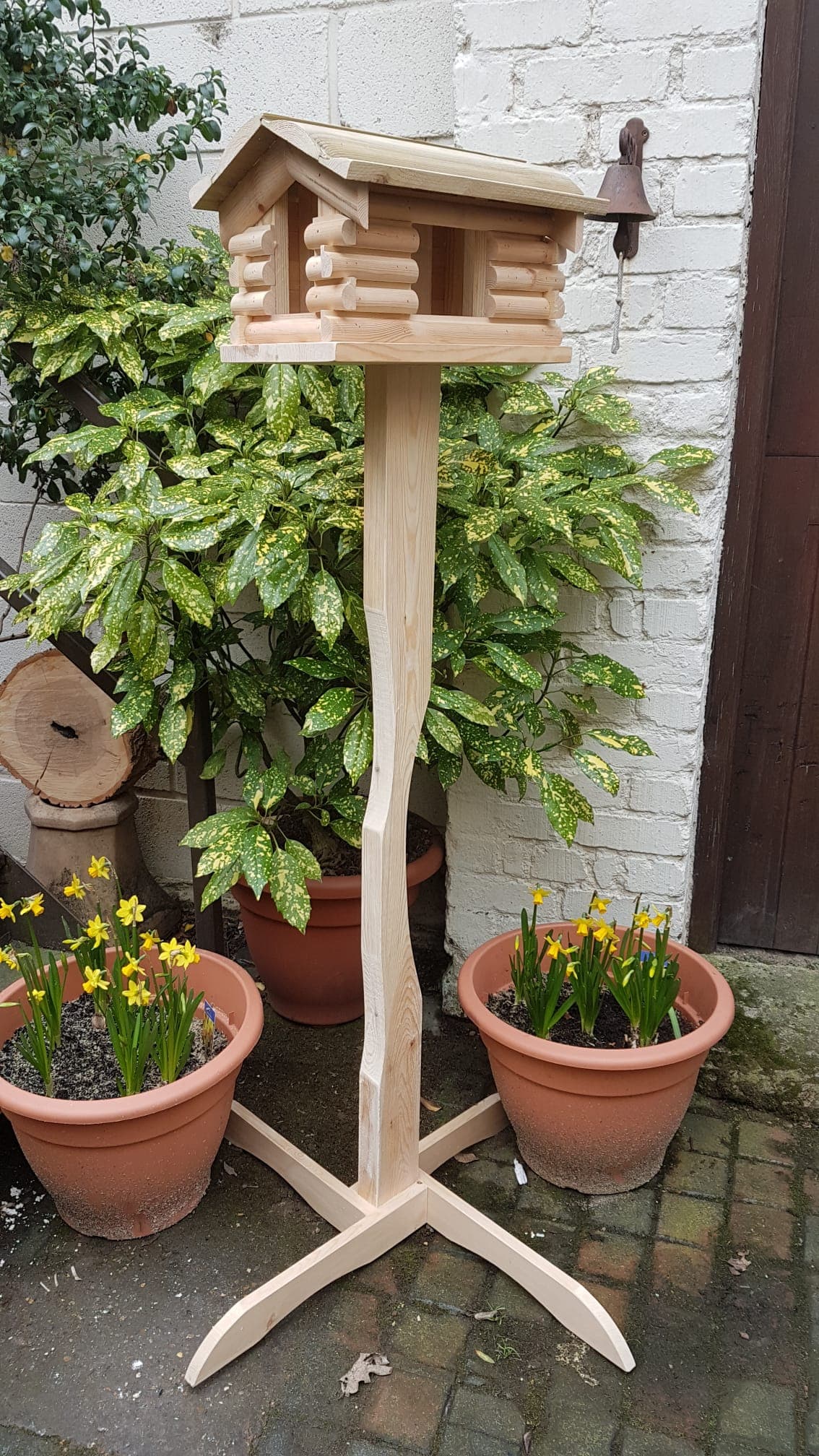 Handcrafted bird house with log cabin style construction