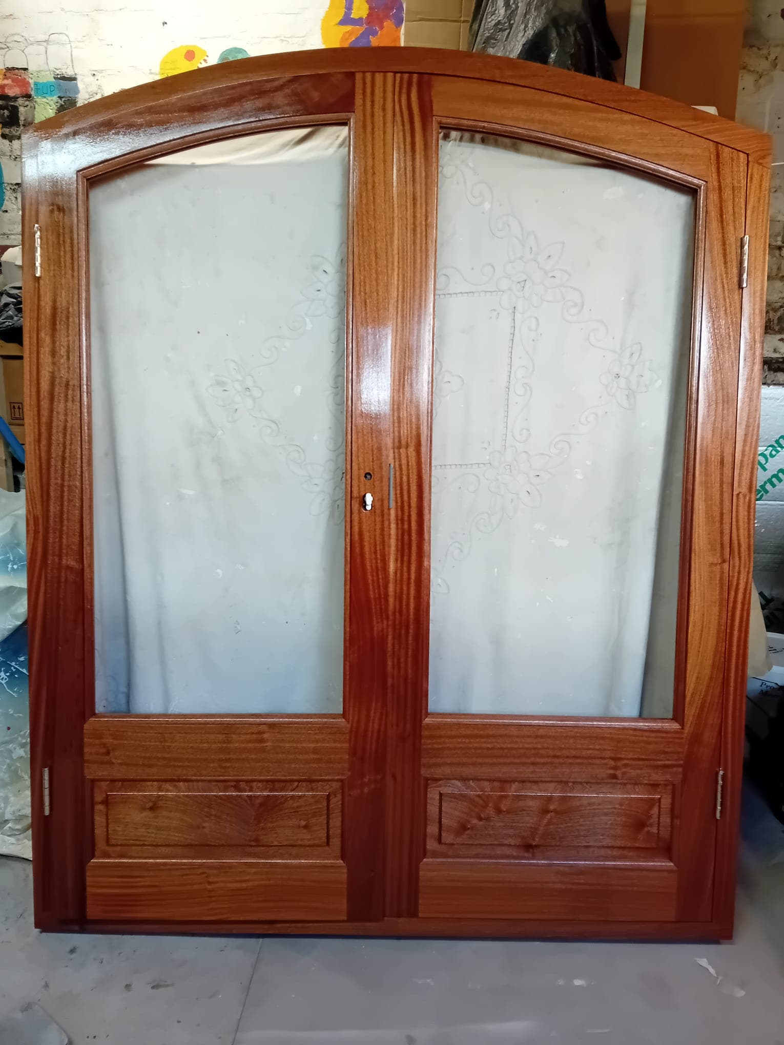 Hardwood French doors with etched glass panels in workshop finishing stage